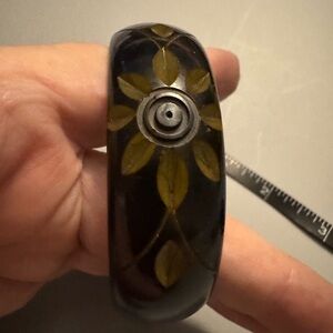 Bakelite black and gold sunshine or flowers engraved in